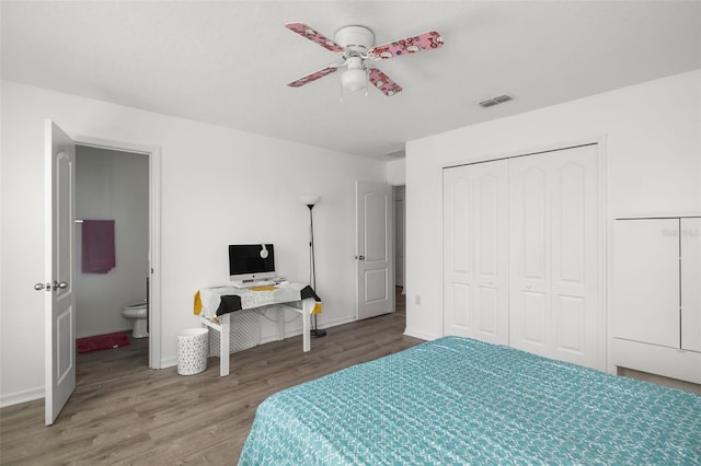 bedroom with a closet, ceiling fan, wood-type flooring, and ensuite bath