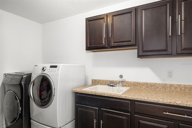 washroom with washer and clothes dryer, cabinets, and sink