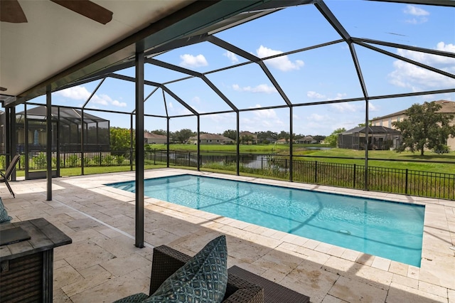 view of swimming pool with glass enclosure, a patio, and a water view