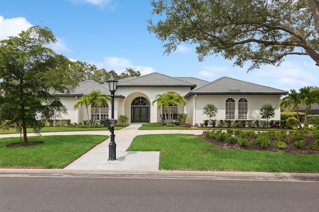 mediterranean / spanish-style house with a front lawn