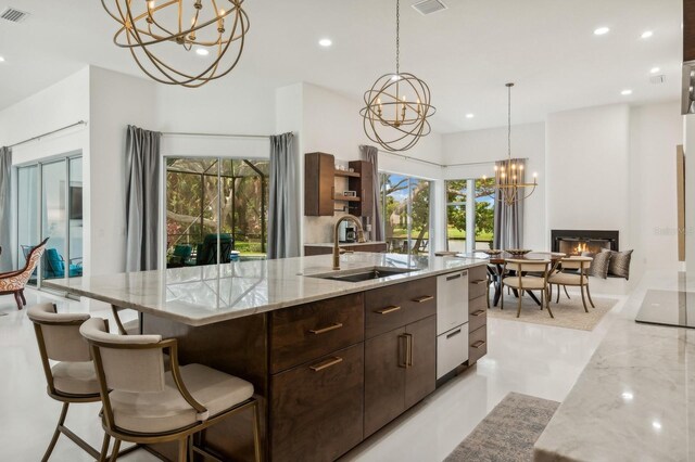 kitchen featuring an inviting chandelier, a spacious island, sink, and decorative light fixtures