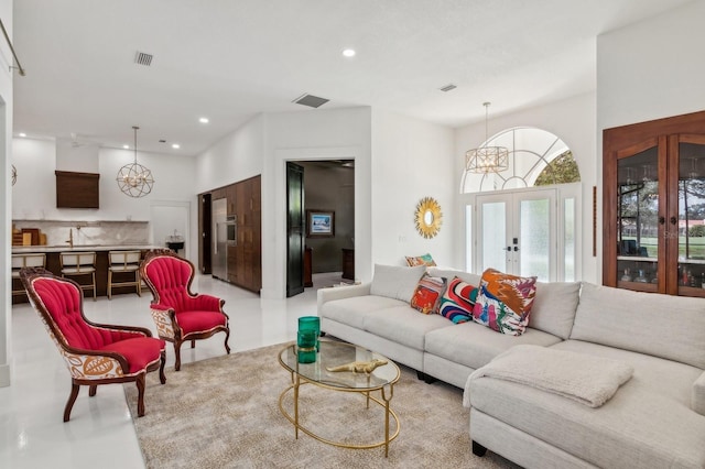 living room featuring a notable chandelier and french doors