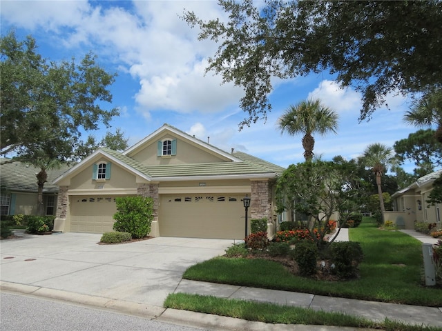 view of front of house featuring a front yard, stucco siding, driveway, stone siding, and an attached garage