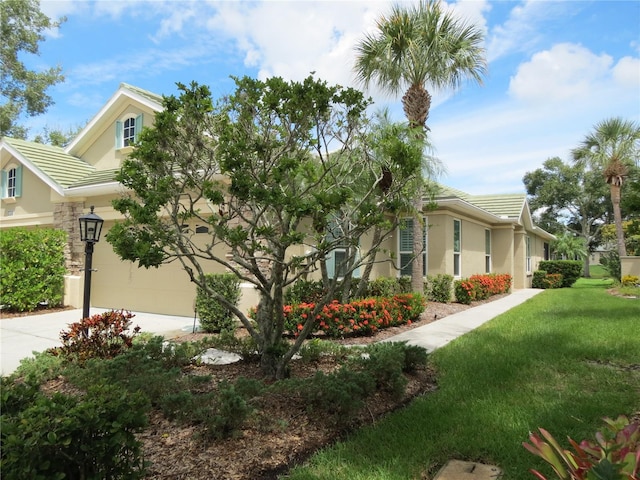 view of property exterior with a tile roof, stucco siding, driveway, and a lawn