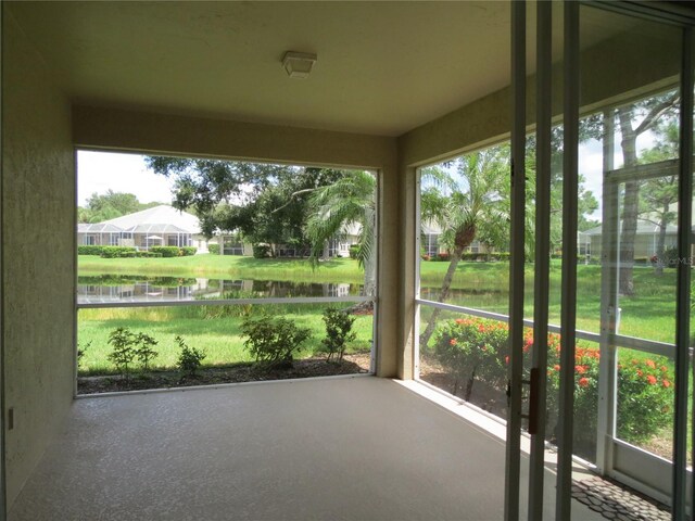 unfurnished sunroom featuring a water view