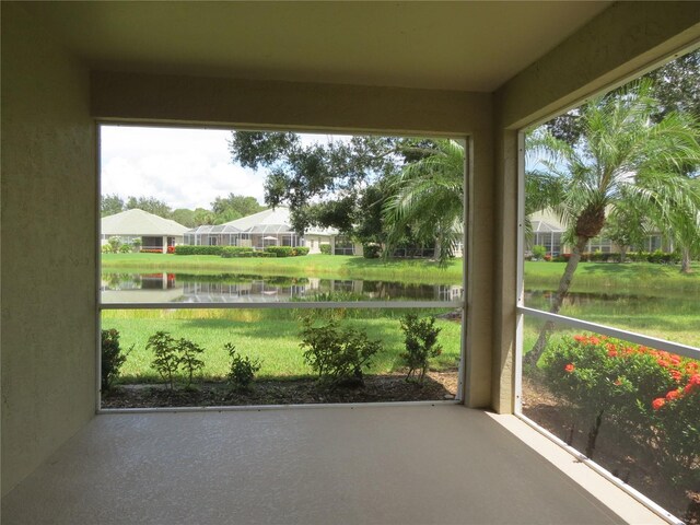 unfurnished sunroom featuring a water view