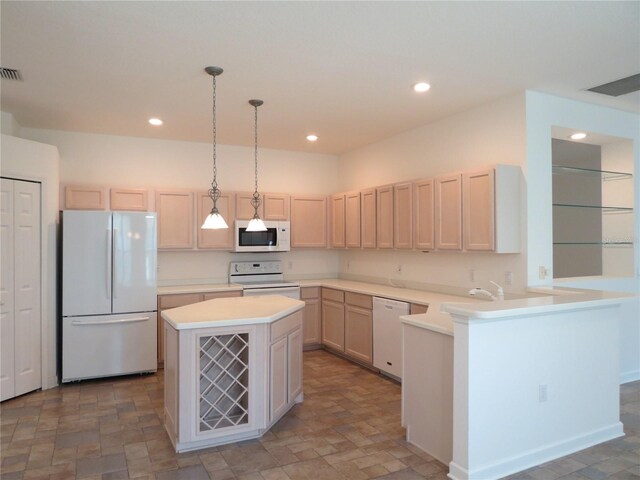 kitchen featuring hanging light fixtures, kitchen peninsula, sink, and white appliances