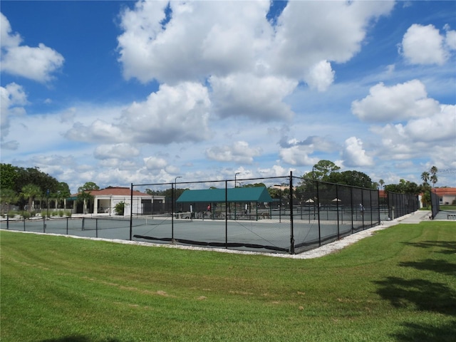 view of tennis court featuring a lawn