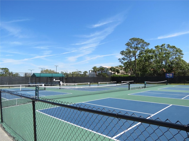 view of tennis court with community basketball court and fence