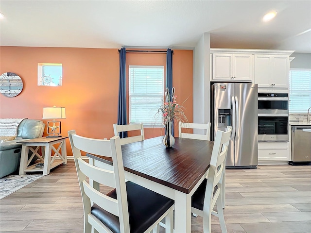 dining area with light hardwood / wood-style flooring and a wealth of natural light