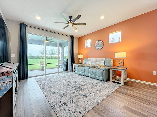 living room featuring light hardwood / wood-style floors, ceiling fan, and a healthy amount of sunlight