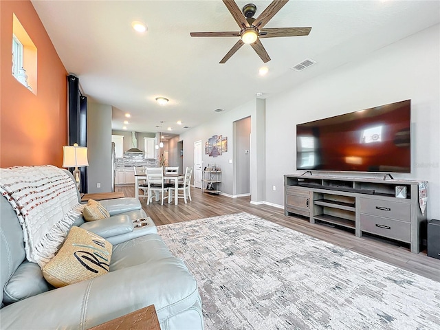 living room featuring ceiling fan and light hardwood / wood-style floors