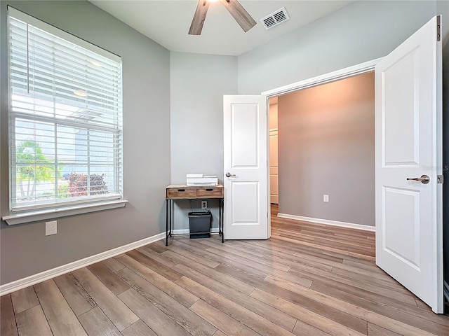 unfurnished office with light wood-type flooring and ceiling fan