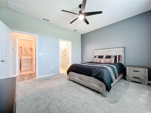 bedroom with wood-type flooring, ceiling fan, ensuite bathroom, and washing machine and dryer