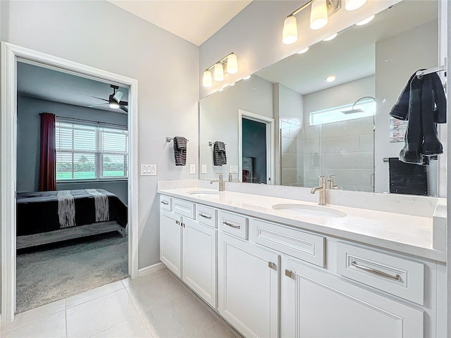 bathroom featuring tiled shower, vanity, ceiling fan, and a wealth of natural light