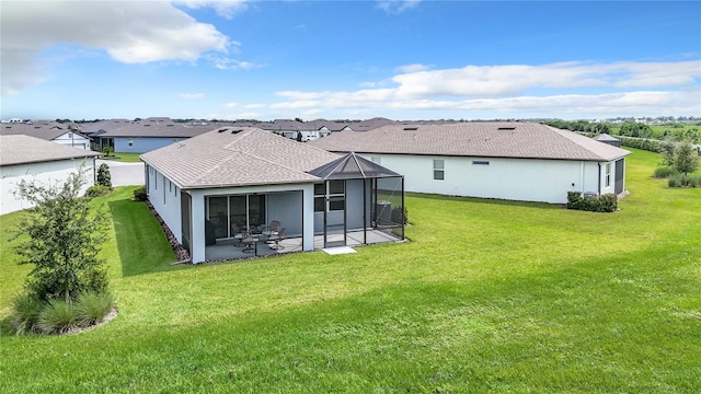 rear view of house featuring a patio, a yard, and a sunroom