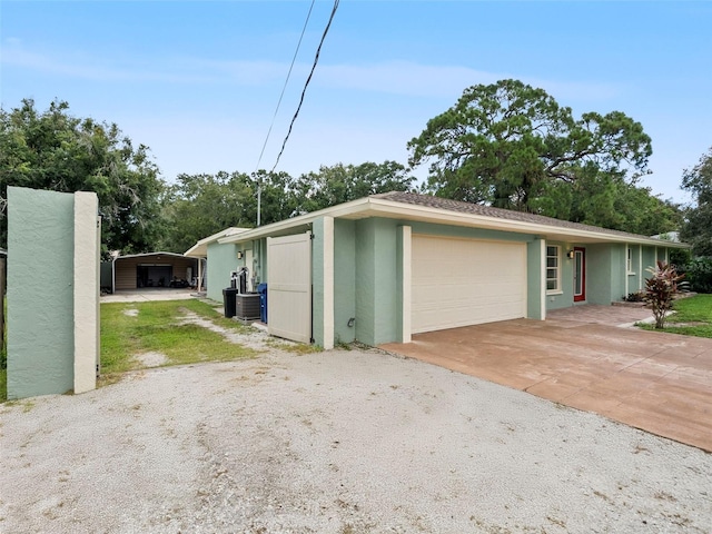 view of side of home with a garage, central air condition unit, and a carport