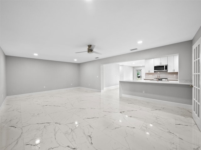 unfurnished living room with ceiling fan