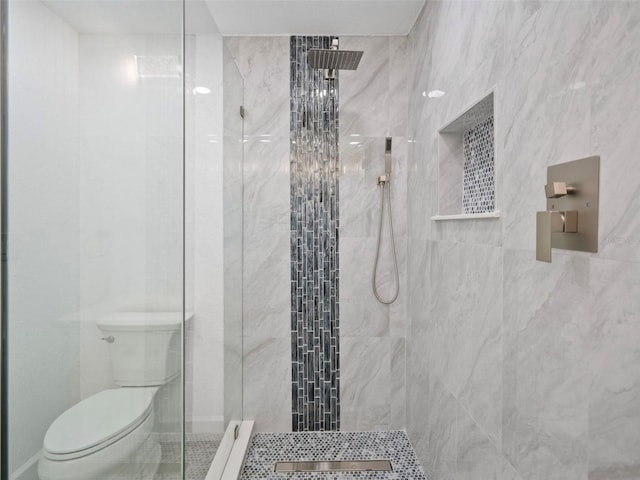 bathroom featuring toilet and a tile shower