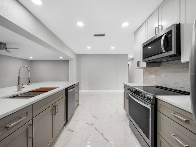 kitchen with ceiling fan, sink, gray cabinetry, and stainless steel appliances