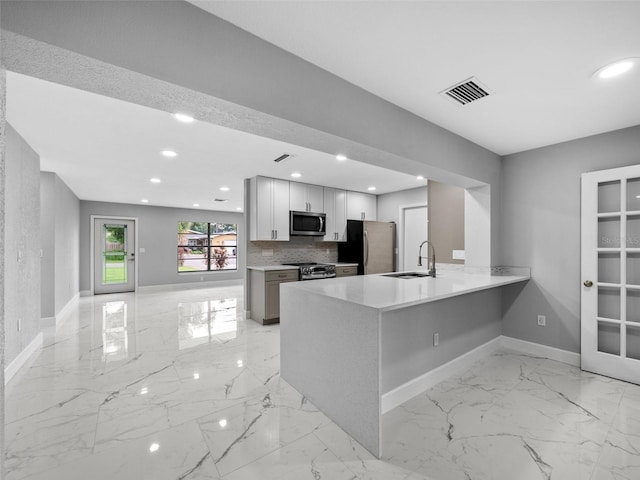 kitchen with white cabinetry, kitchen peninsula, stainless steel appliances, backsplash, and sink