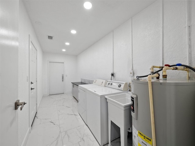 washroom featuring washer and clothes dryer, water heater, and sink