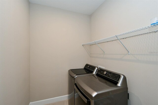 laundry room with tile patterned flooring and washer and dryer