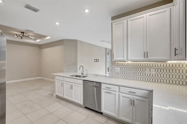 kitchen with white cabinets, backsplash, and stainless steel dishwasher