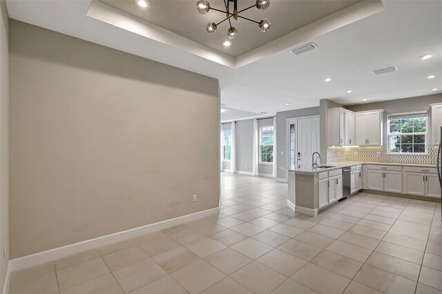 kitchen featuring a wealth of natural light, kitchen peninsula, sink, and stainless steel dishwasher