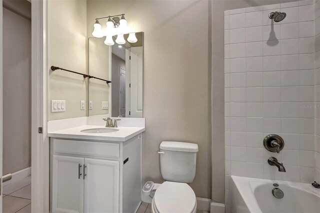 full bathroom featuring tiled shower / bath, vanity, tile patterned flooring, and toilet