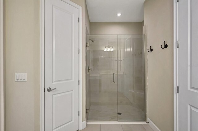 bathroom with a shower with shower door and tile patterned flooring