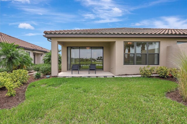 back of property with a patio area and a yard