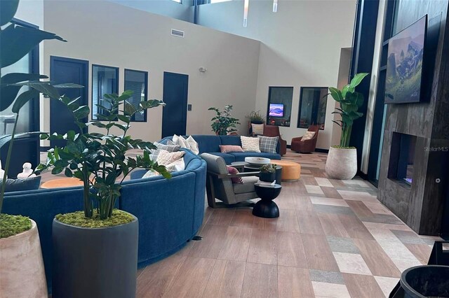 living room with a high ceiling, hardwood / wood-style floors, and a fireplace