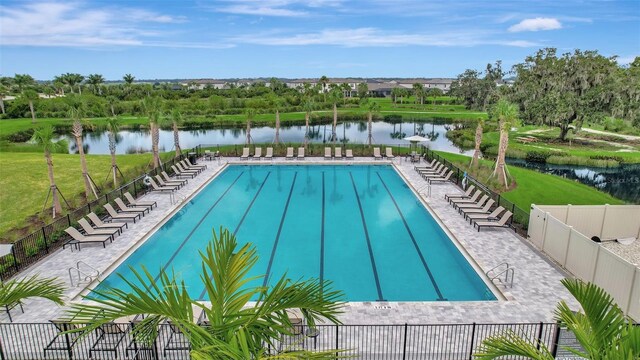 view of swimming pool featuring a patio and a water view