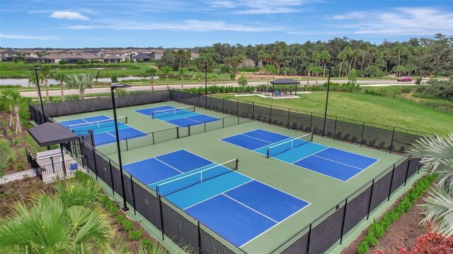 view of tennis court featuring a water view