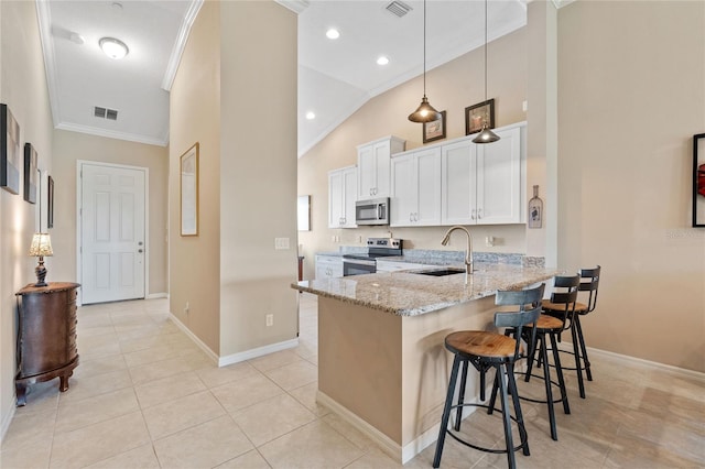 kitchen with hanging light fixtures, light stone countertops, stainless steel appliances, white cabinetry, and a breakfast bar area