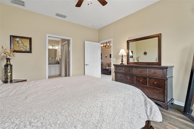 bedroom featuring connected bathroom, hardwood / wood-style floors, and ceiling fan