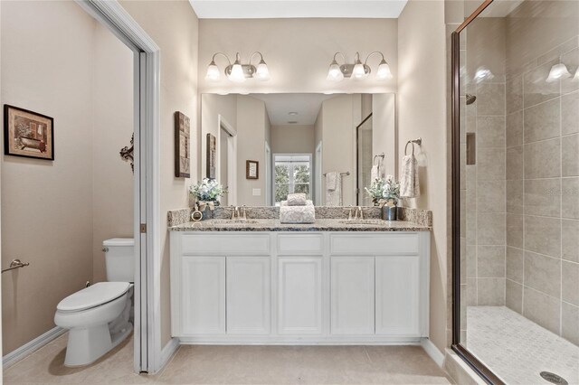 bathroom featuring vanity, toilet, a shower with shower door, and tile patterned floors