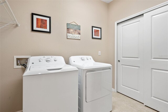 laundry room featuring light tile patterned floors and separate washer and dryer