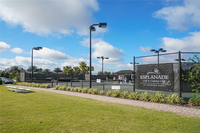 view of tennis court featuring a lawn