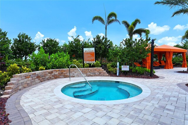 view of pool featuring a community hot tub and a gazebo