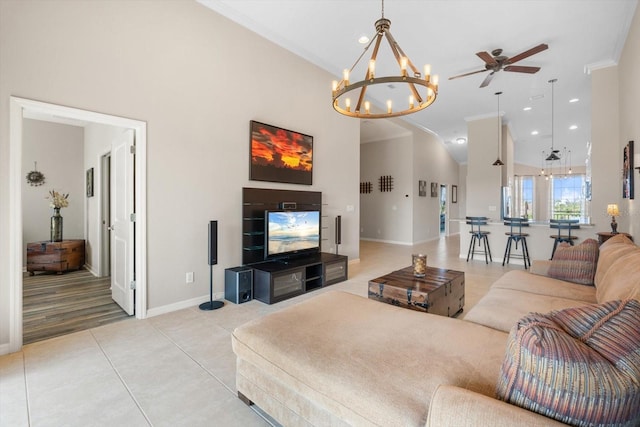 living room featuring high vaulted ceiling, light tile patterned flooring, ceiling fan with notable chandelier, baseboards, and crown molding