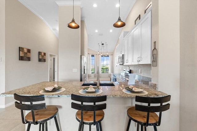 kitchen with light stone countertops, crown molding, appliances with stainless steel finishes, and a sink