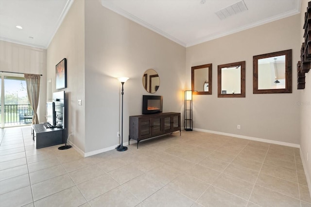 sitting room featuring baseboards, visible vents, a glass covered fireplace, crown molding, and light tile patterned flooring