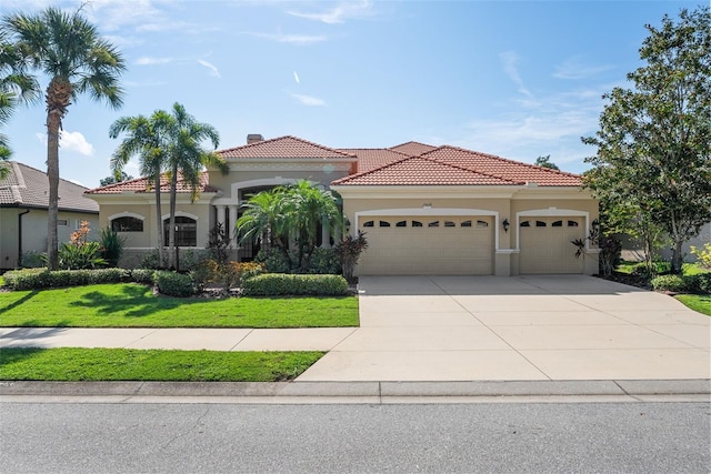 mediterranean / spanish-style home with a front lawn and a garage