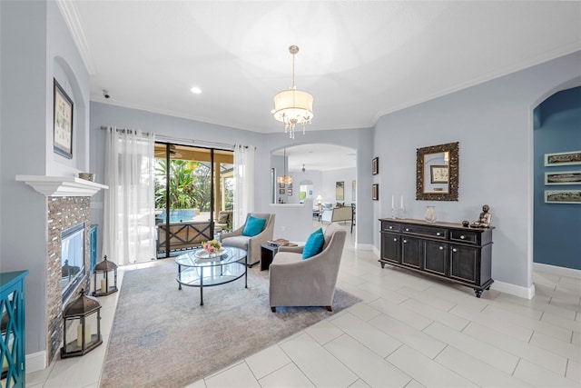 tiled living room with an inviting chandelier, ornamental molding, and a tiled fireplace