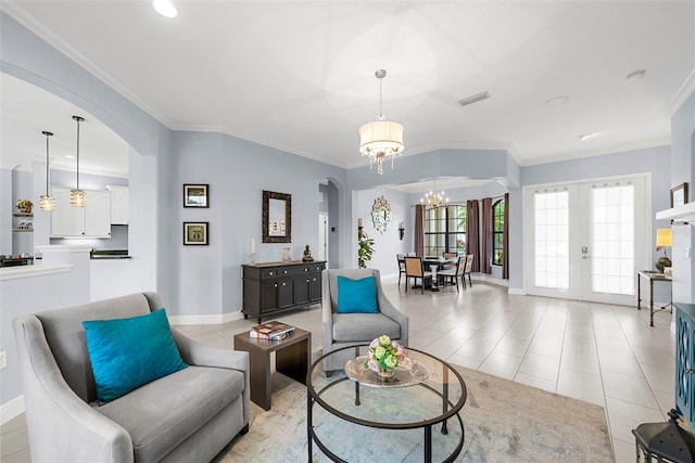 tiled living room featuring a chandelier, french doors, and ornamental molding