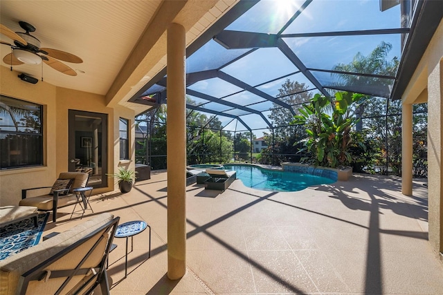 view of swimming pool featuring pool water feature, a patio, glass enclosure, and ceiling fan