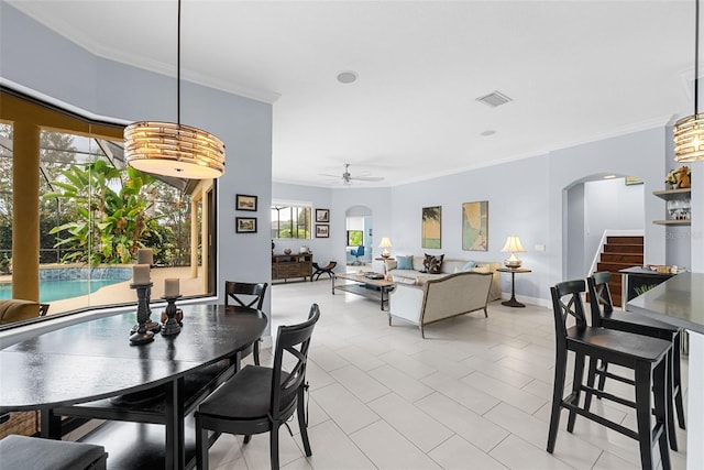 dining area with ceiling fan, ornamental molding, and light tile patterned floors