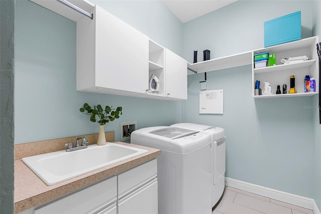 laundry room with cabinets, washing machine and dryer, light tile patterned floors, and sink